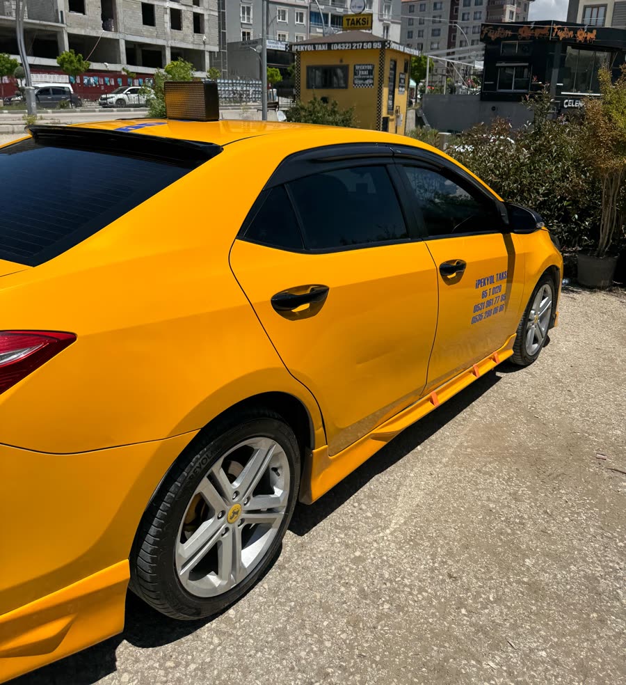 Van şehirler arası taksi yolculuğu için sarı Toyota Corolla